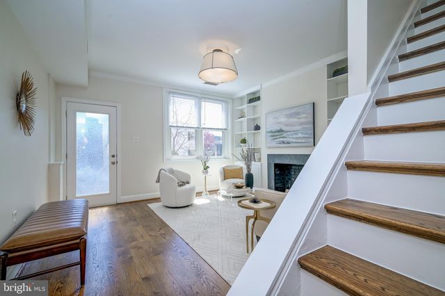 a living room with furniture a fireplace and a chandelier