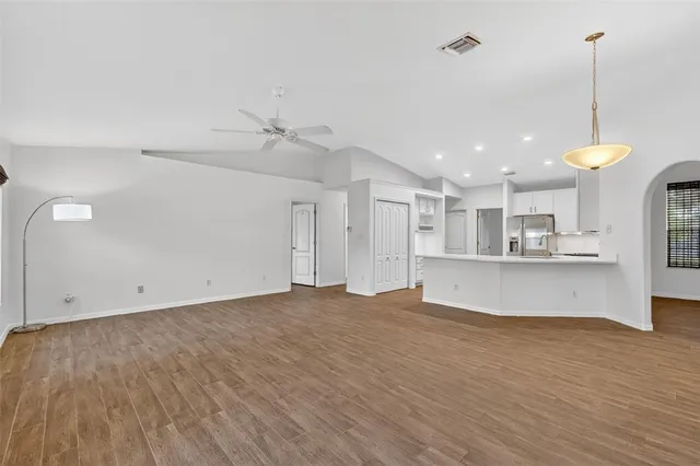 a view of an empty room with window and wooden floor