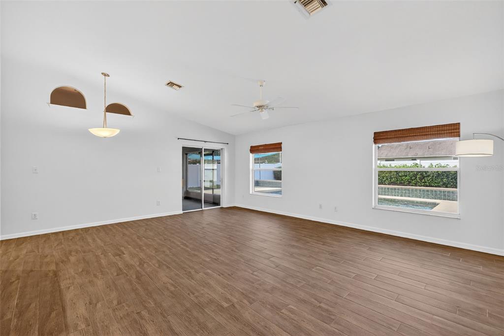 2113 Wolf Ridge Lane Mount Dora, FL 32757 - Photo 16 of 49 a view of an empty room with wooden floor and a window