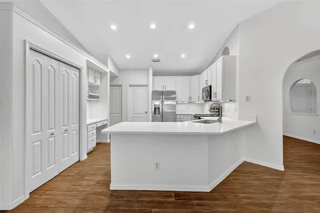 a view of kitchen with stainless steel appliances granite countertop cabinets and wooden floor
