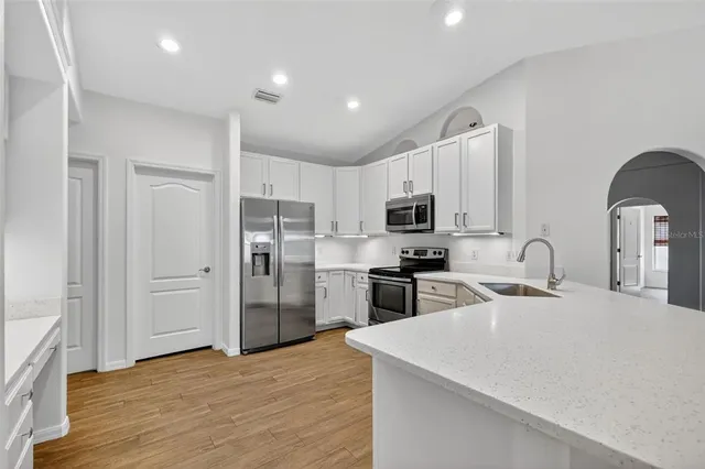 a kitchen with stainless steel appliances granite countertop a refrigerator sink and stove