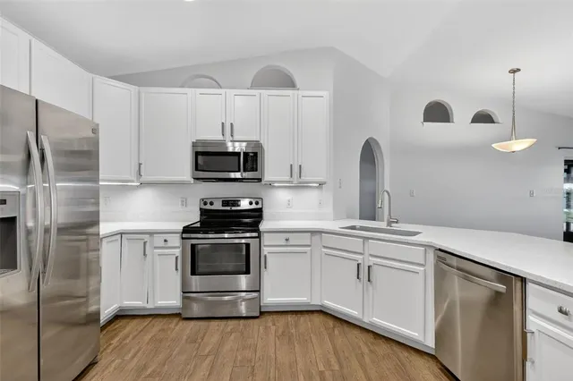 a kitchen with stainless steel appliances granite countertop a stove a sink and a refrigerator