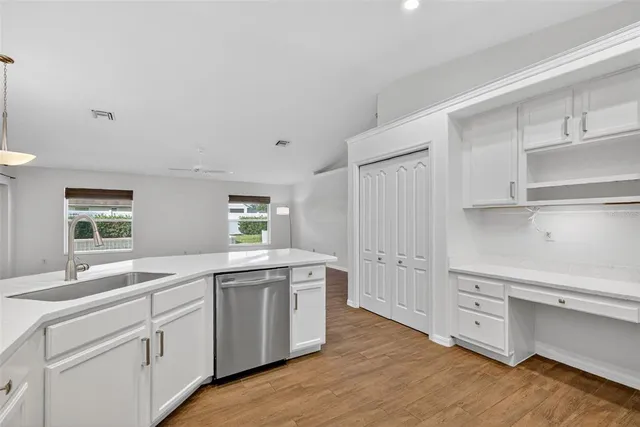 a kitchen with white cabinets and sink