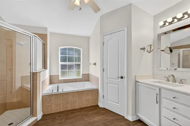 a bathroom with a tub a sink and mirrors
