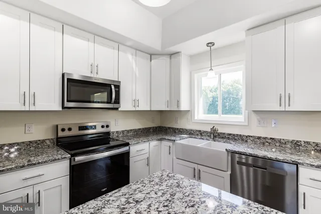 a kitchen with stainless steel appliances granite countertop a stove a sink and a refrigerator