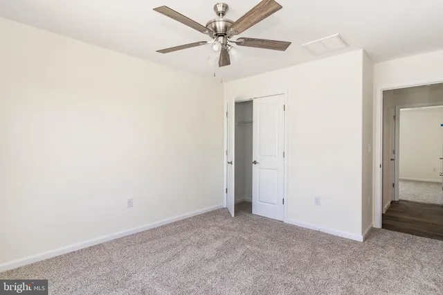 an empty room with a window and a fan