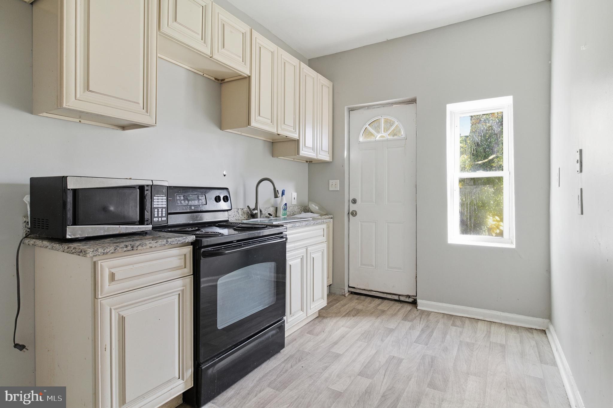 a kitchen with stainless steel appliances granite countertop a sink a stove a microwave and wooden cabinets