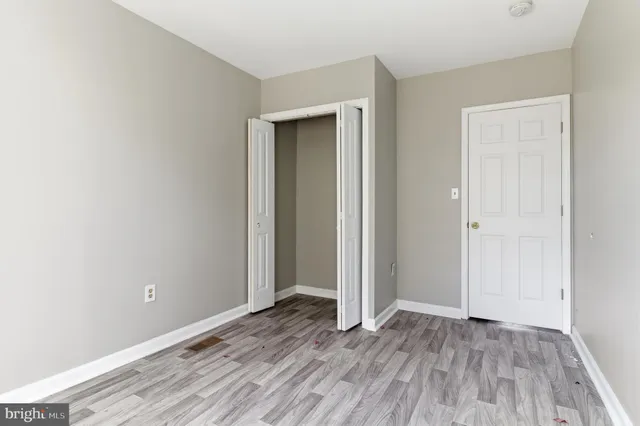 an empty room with wooden floor and closet