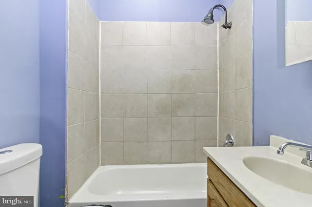 a bath tub sitting next to a white sink and a toilet