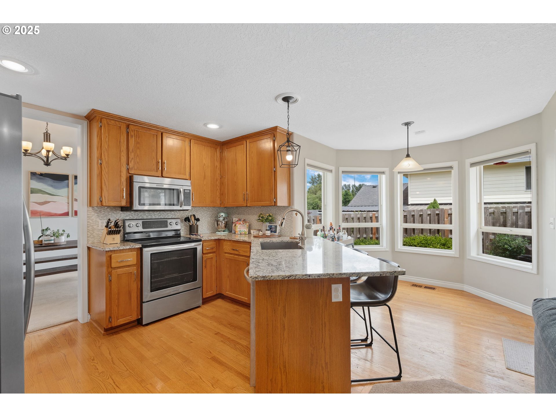 2326 Southeast Robin Lane Gresham, OR 97080 - Photo 10 of 33 a kitchen with stainless steel appliances granite countertop a stove refrigerator and a view of living room
