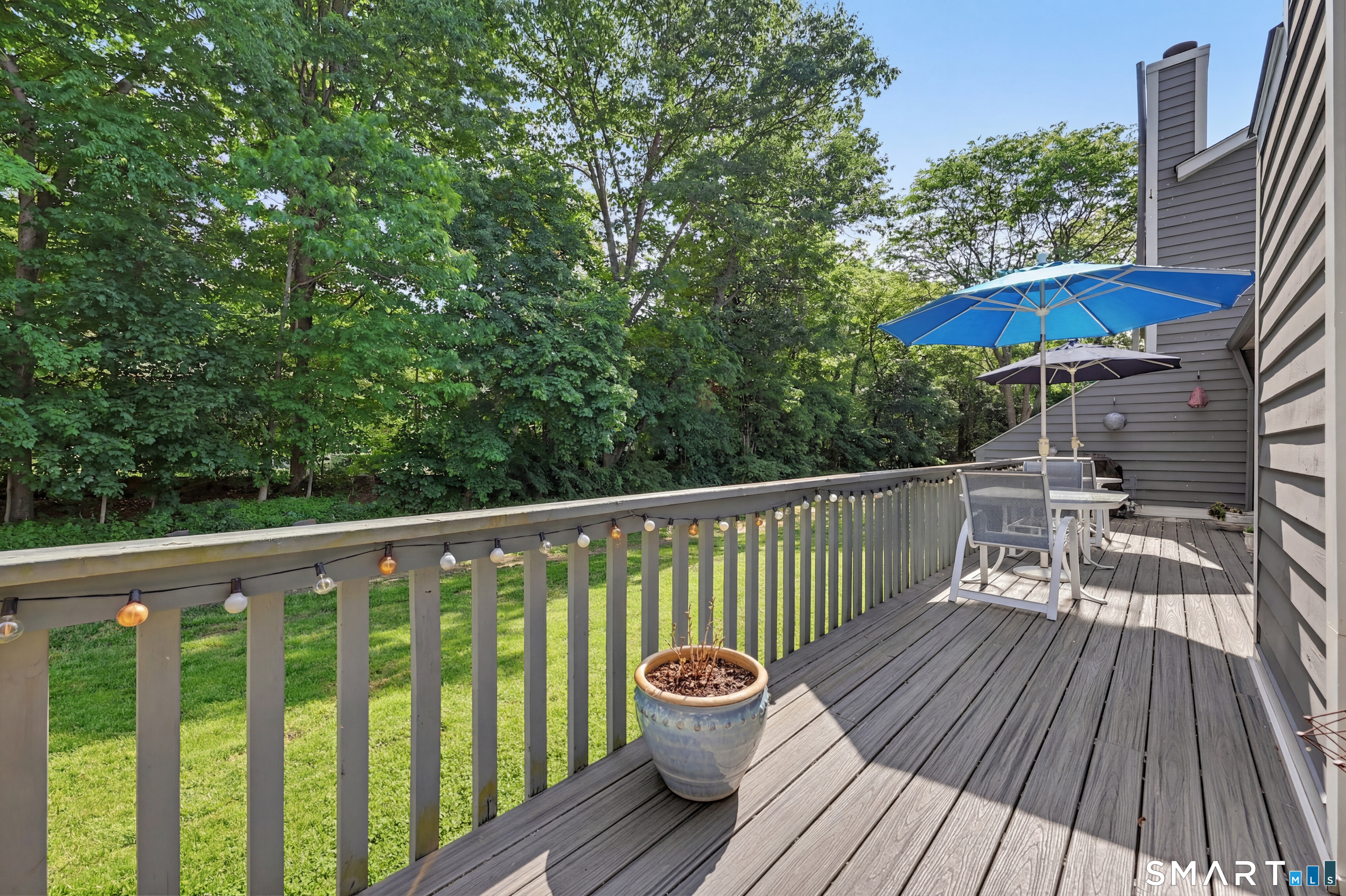 70 Fawn Ridge Lane, Unit 70 Norwalk, CT 06851 - Photo 23 of 36 a view of a wooden deck with a table and chairs