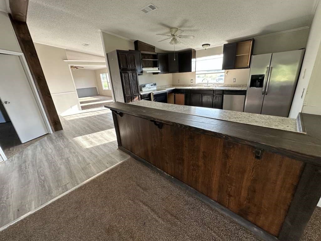 102 Bailey Street Van Alstyne, TX 75495 - Photo 4 of 14 a kitchen with stainless steel appliances a sink a microwave a refrigerator and cabinets