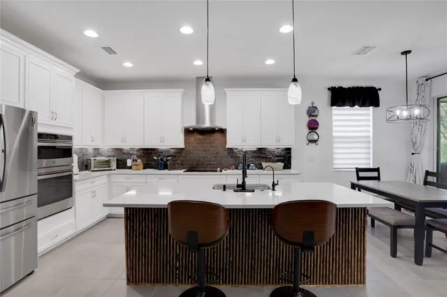 a kitchen with a center island appliances and cabinets