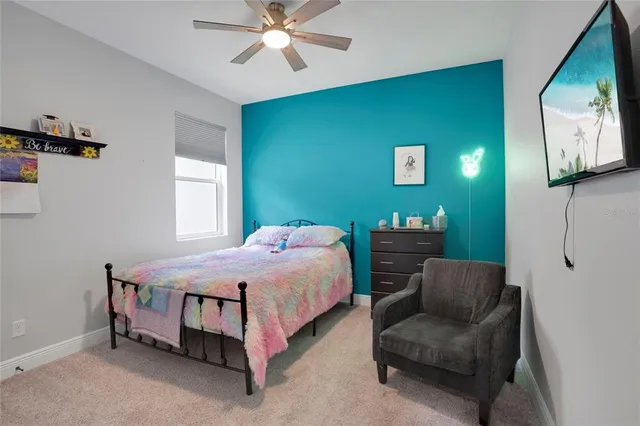 a bedroom with a bed and a chandelier fan