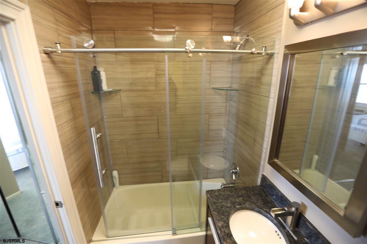 9400 Atlantic Avenue, Unit 709 Margate City, NJ 08402 - Photo 11 of 11 a bathroom with a granite countertop sink toilet and shower