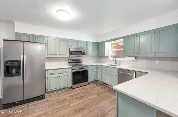 a kitchen with cabinets a sink and appliances