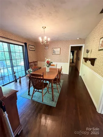 a dining room with furniture a chandelier and wooden floor