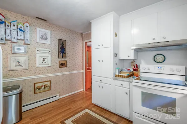 a kitchen with white cabinets and white appliances