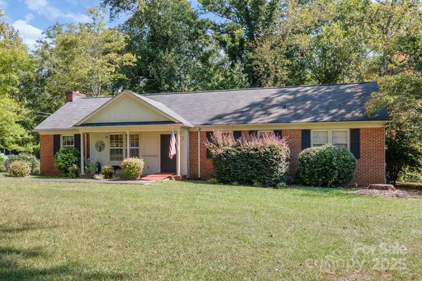 a front view of a house with yard and green space