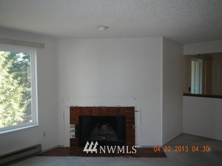 2517 Northeast 4th Street, Unit 524 Renton, WA 98056 - Photo 5 of 10 a living room with a fireplace and a window