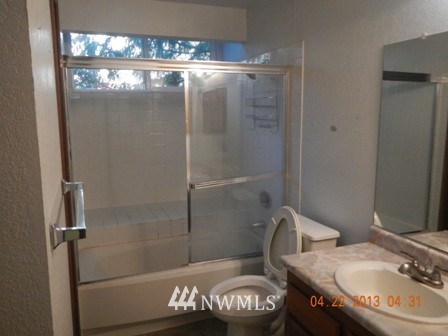 2517 Northeast 4th Street, Unit 524 Renton, WA 98056 - Photo 7 of 10 a bathroom with a granite countertop sink toilet and shower
