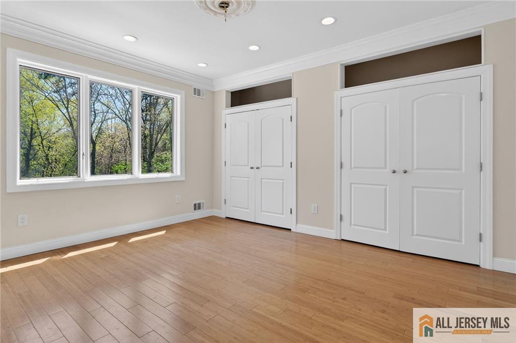 381 Monmouth Road Freehold, NJ 07728 - Photo 50 of 63 a view of an empty room with wooden floor and a window