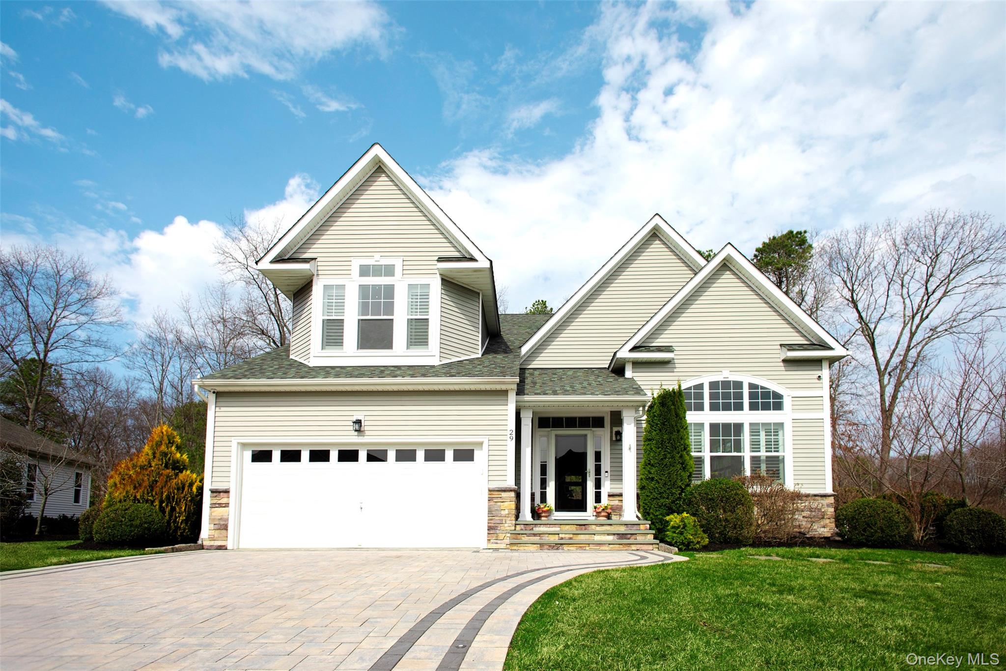 29 Wild Flower Drive Ridge, NY 11961 - Photo 2 of 45 a front view of a house with a yard and garage