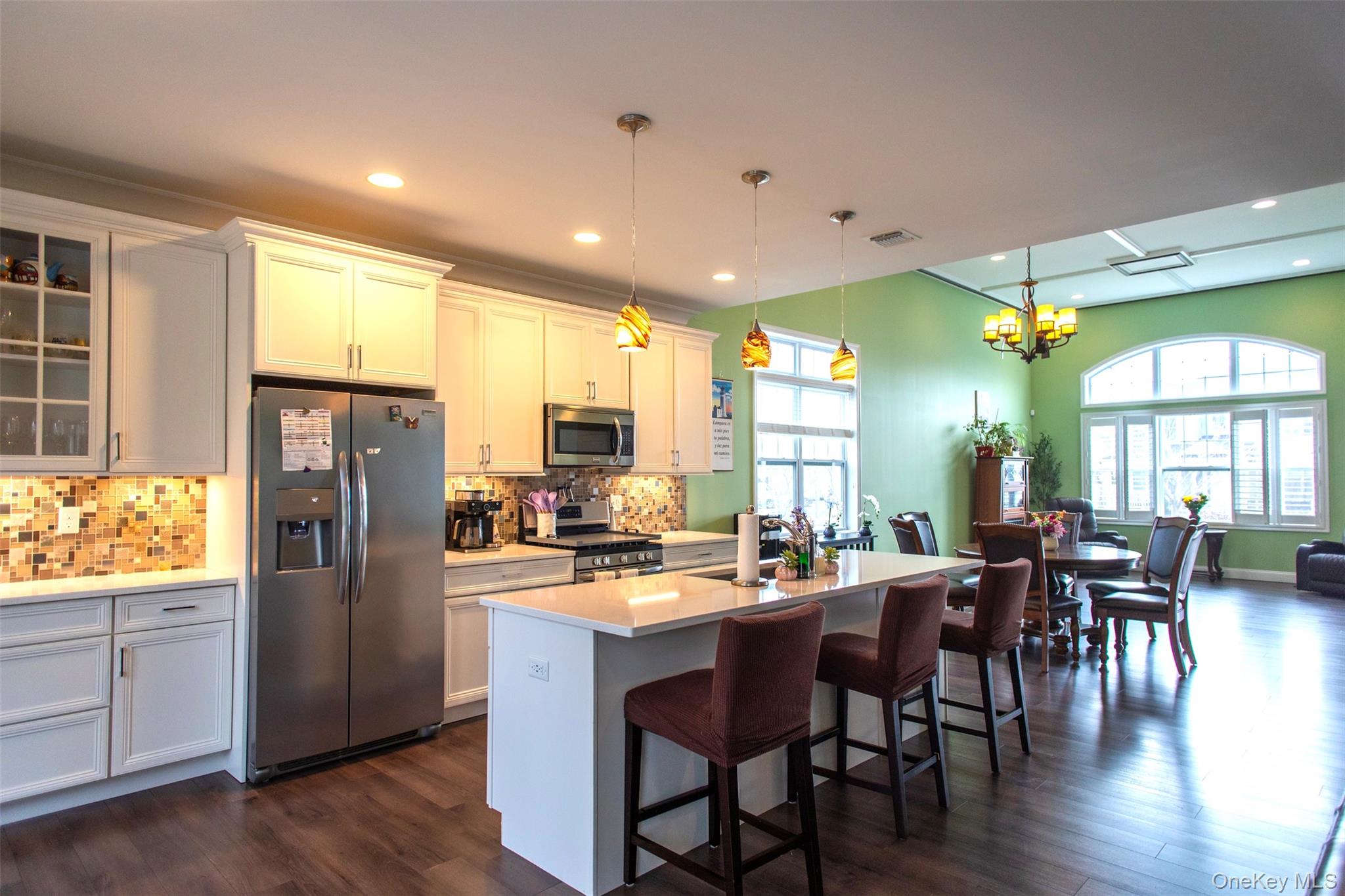 29 Wild Flower Drive Ridge, NY 11961 - Photo 9 of 45 a kitchen with stainless steel appliances granite countertop dining table chairs and wooden floor