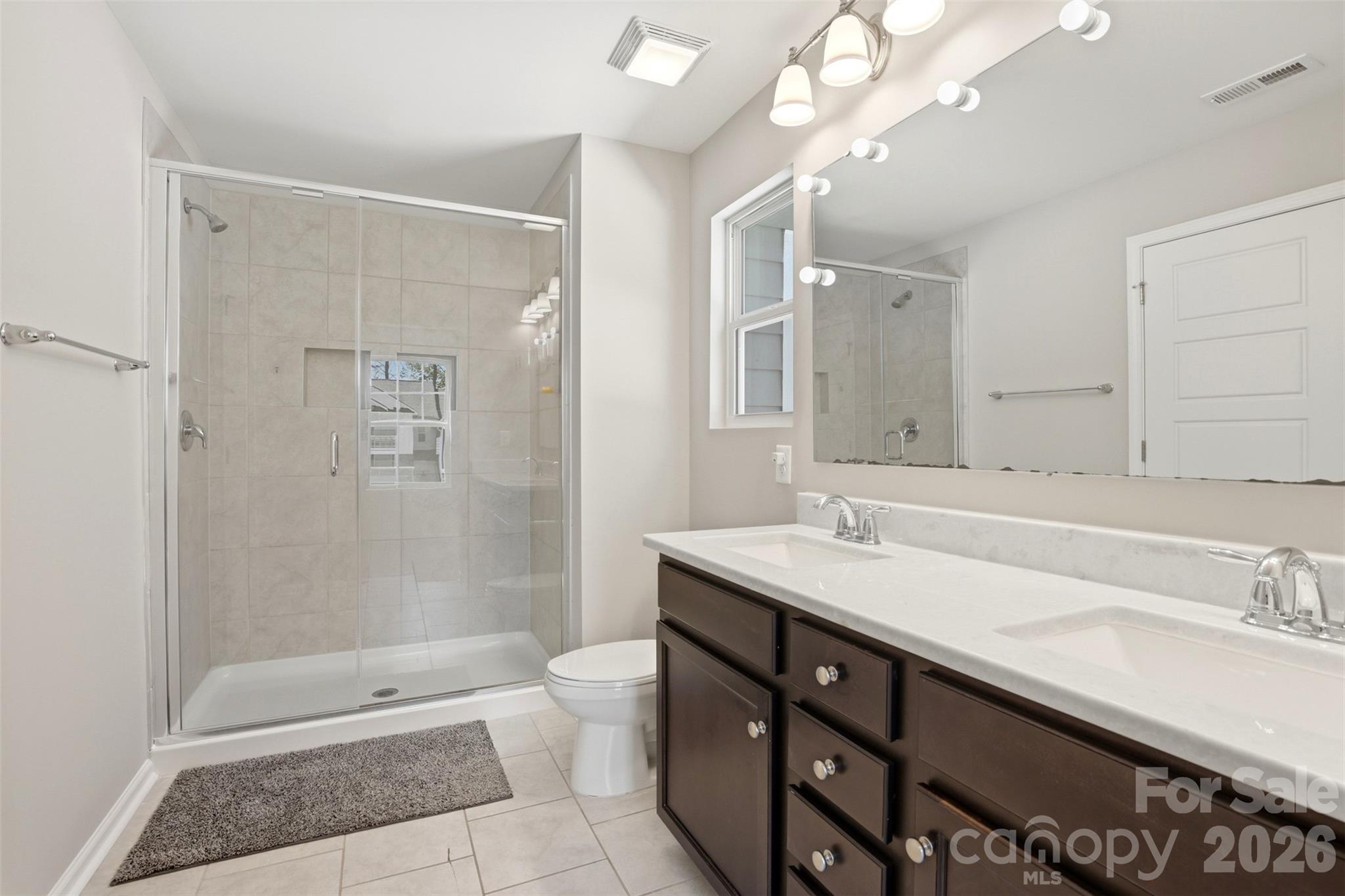 1117 Streamside Lane York, SC 29745 - Photo 17 of 25 a bathroom with a granite countertop sink a toilet a shower and a mirror