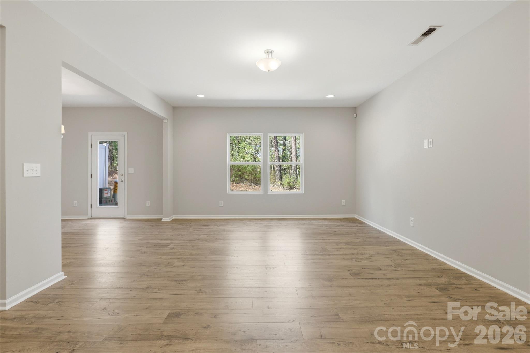 1117 Streamside Lane York, SC 29745 - Photo 3 of 25 an empty room with wooden floor and windows