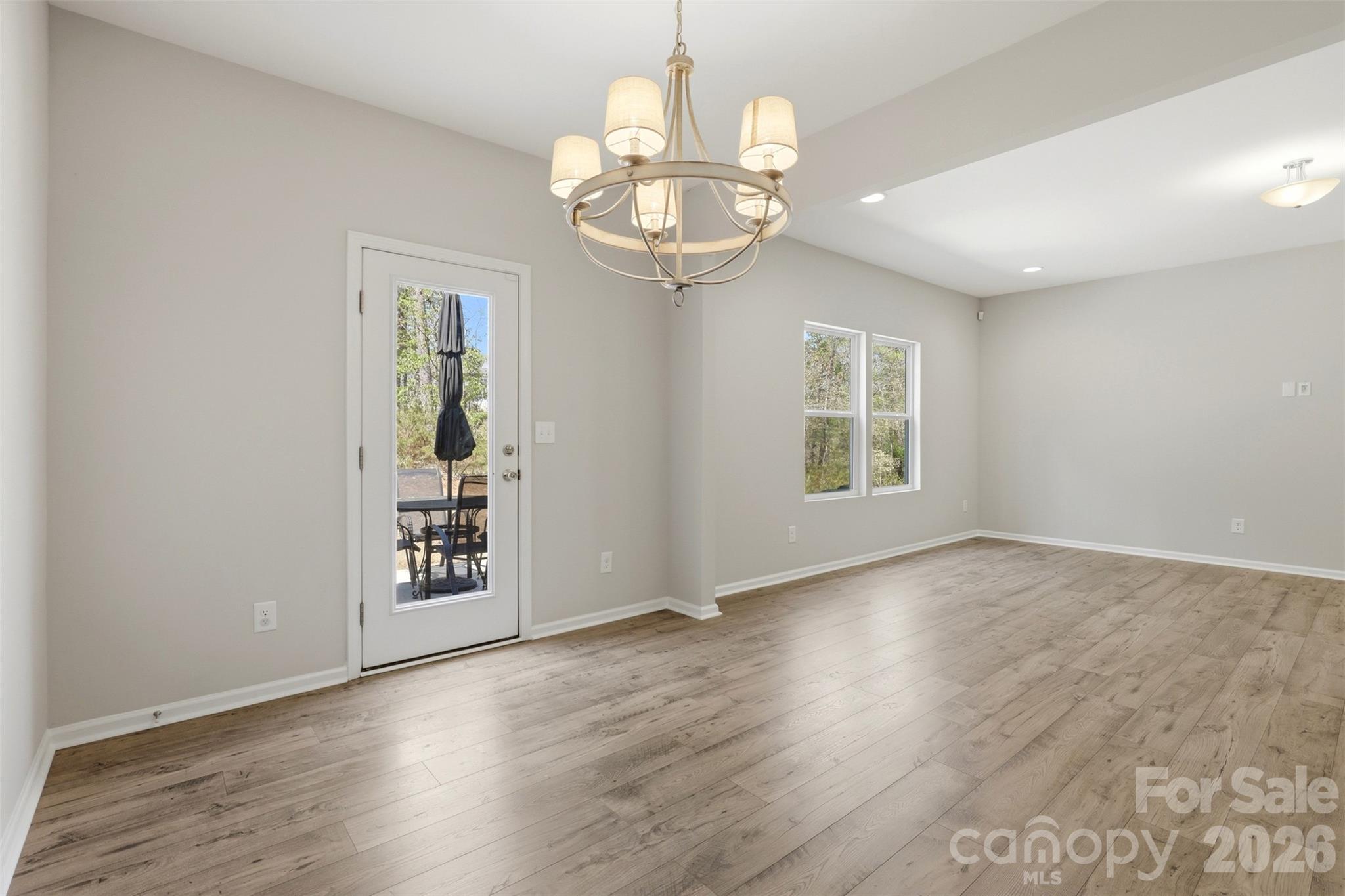 1117 Streamside Lane York, SC 29745 - Photo 8 of 25 an empty room with wooden floor chandelier and windows