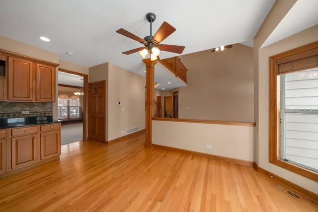 a view of a kitchen with wooden floor and a ceiling fan