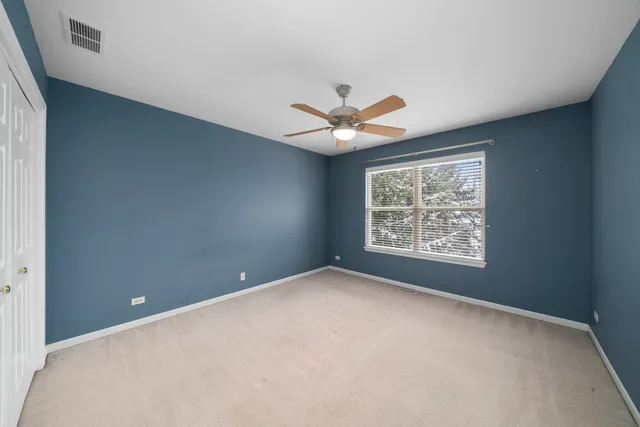 an empty room with a window and a ceiling fan