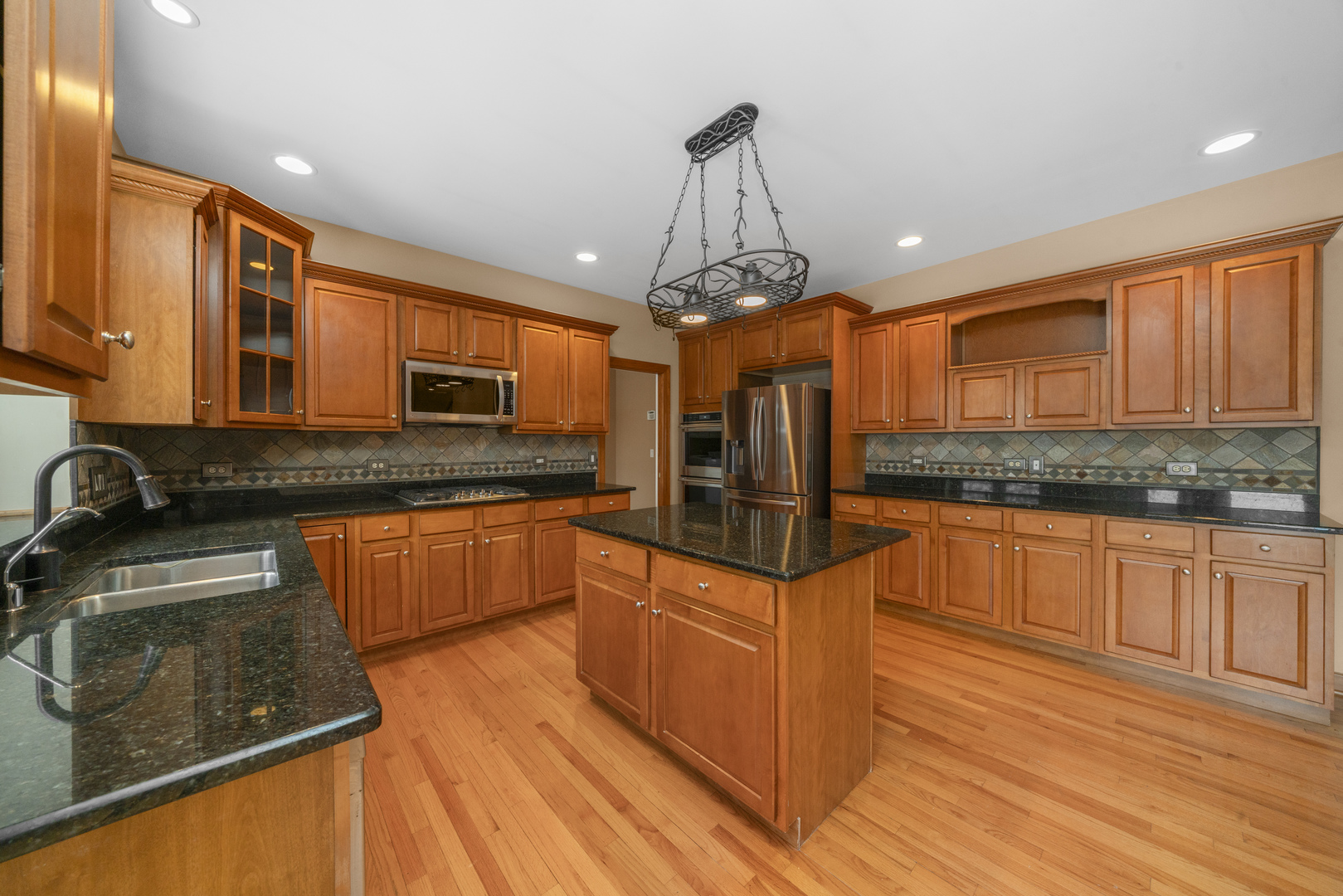 757 Merrill New Road Sugar Grove, IL 60554 - Photo 6 of 51 a kitchen with stainless steel appliances granite countertop a sink a stove top oven a counter space and cabinets