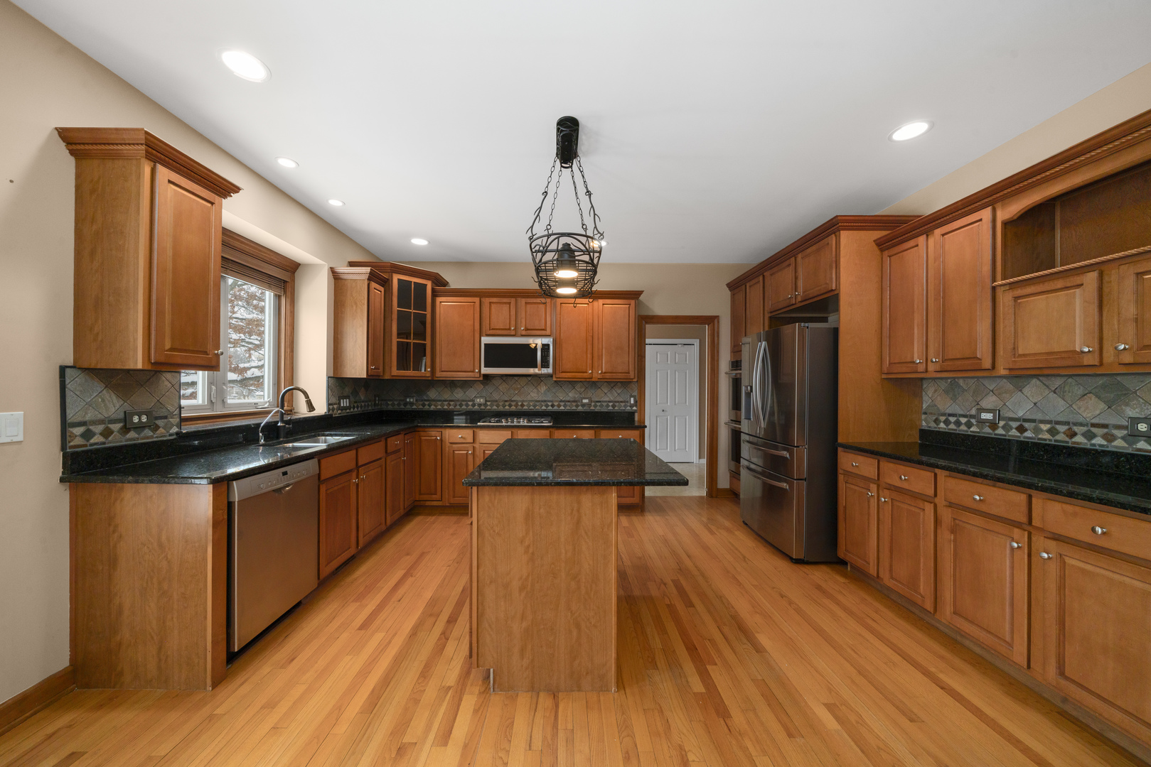 757 Merrill New Road Sugar Grove, IL 60554 - Photo 7 of 51 a large kitchen with granite countertop a large counter top space a sink stainless steel appliances and cabinets