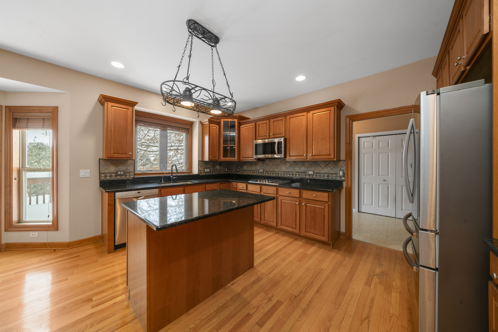 757 Merrill New Road Sugar Grove, IL 60554 - Photo 8 of 51 a kitchen with stainless steel appliances granite countertop wooden floors granite counter tops and a window