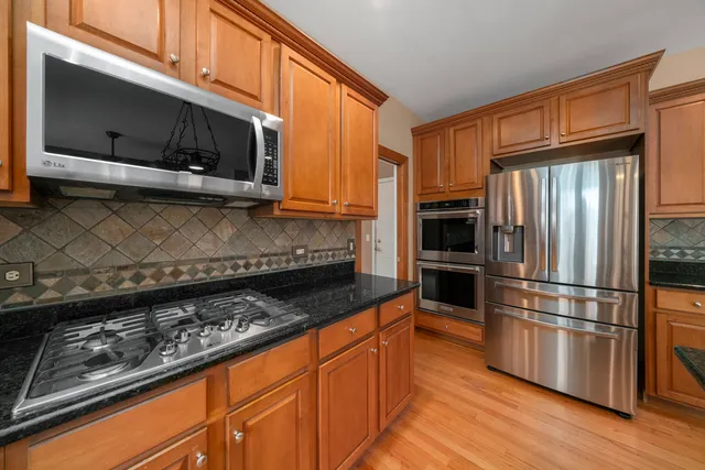 a kitchen with granite countertop a refrigerator stove and microwave