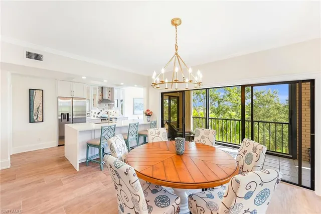 a dining room with furniture a chandelier and wooden floor