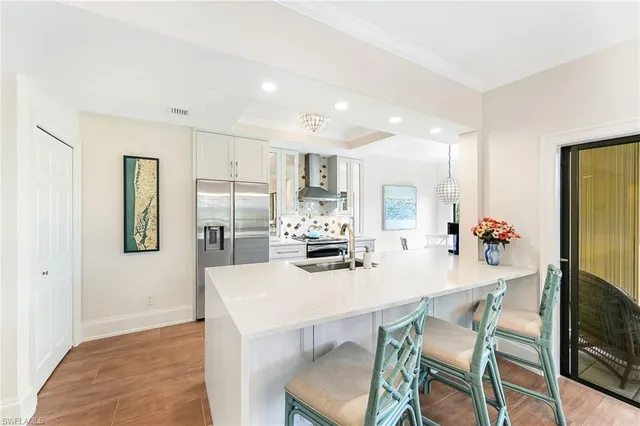 a kitchen with kitchen island a table and chairs in it