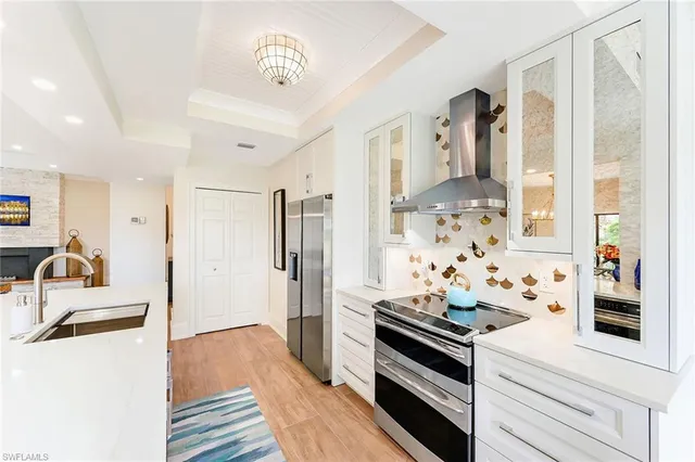 a kitchen with stainless steel appliances a stove a sink a refrigerator and cabinets