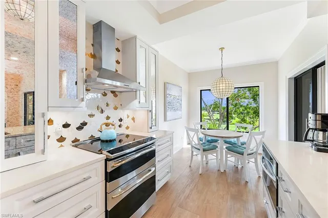 a kitchen with stainless steel appliances a stove a table and chairs