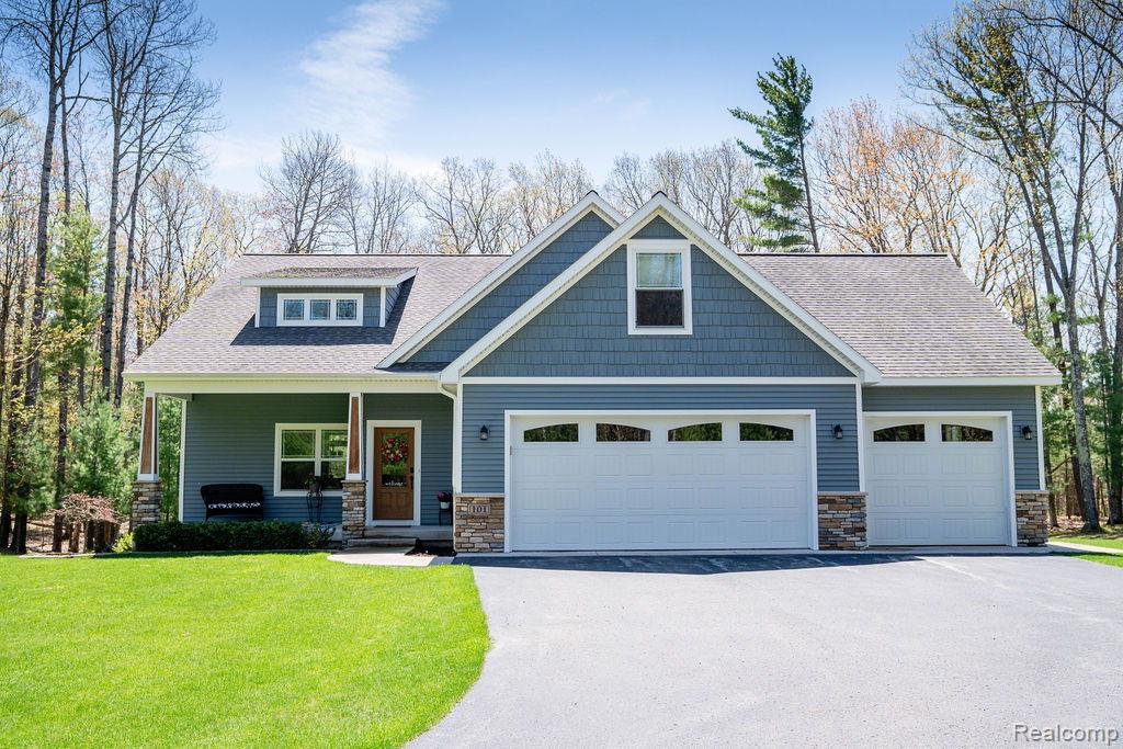 101 Highview Road Traverse City, MI 49696 - Photo 1 of 88 Craftsman house featuring stone siding, driveway, covered porch, and roof with shingles