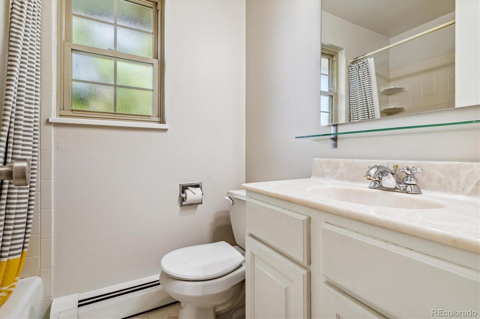 1975 South Locust Street Denver, CO 80224 - Photo 29 of 40 a bathroom with a granite countertop toilet sink and mirror