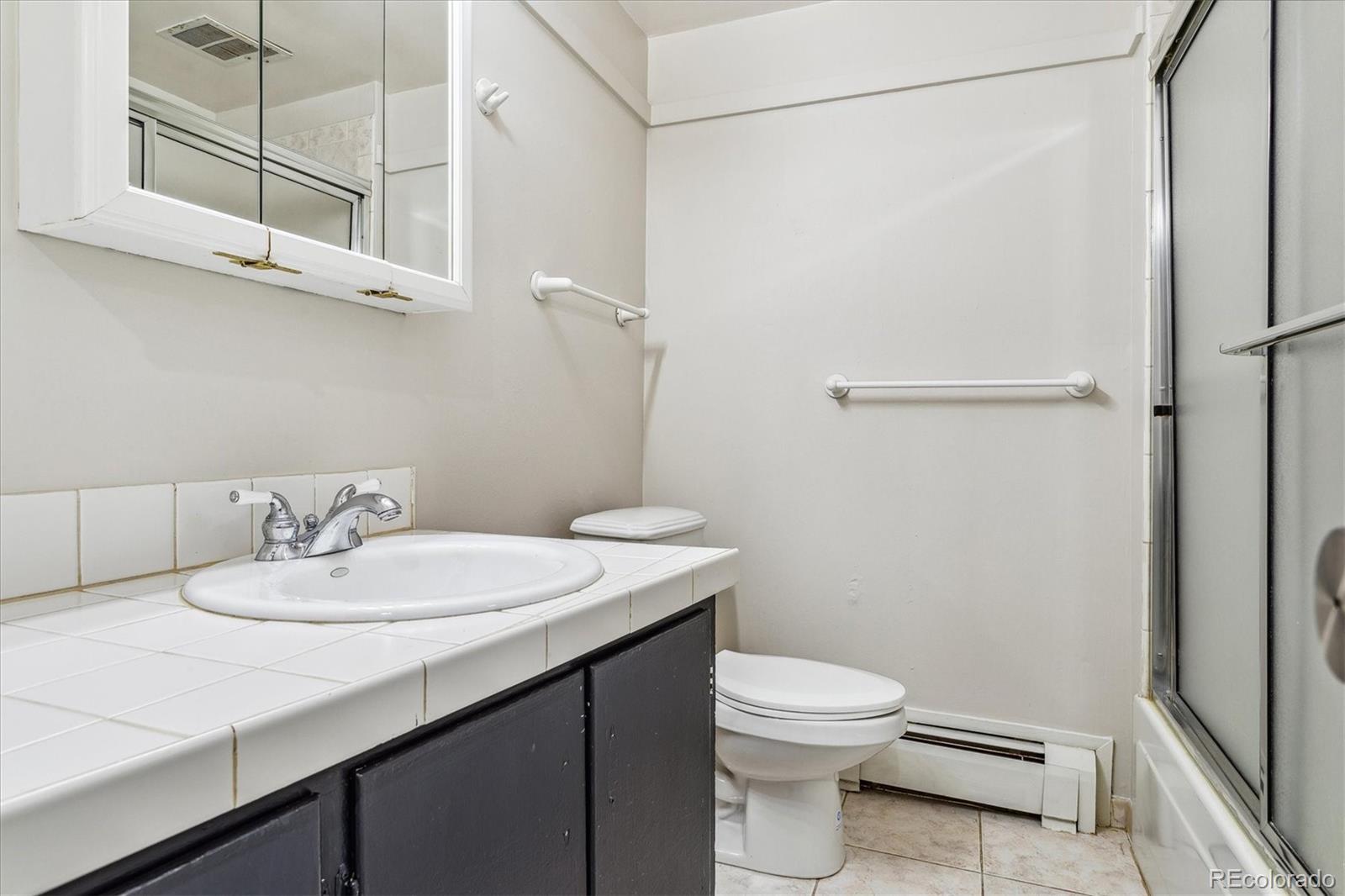 1975 South Locust Street Denver, CO 80224 - Photo 33 of 40 a bathroom with a sink a toilet and shower