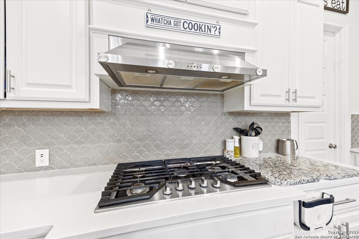 6957 Hallie Loop Schertz, TX 78154 - Photo 14 of 51 a close view of a stove a microwave and cabinets
