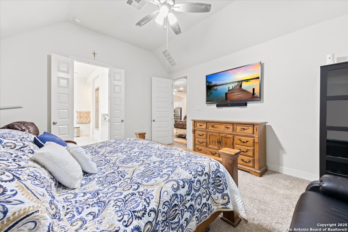 6957 Hallie Loop Schertz, TX 78154 - Photo 24 of 51 a bedroom with a bed and a flat screen tv