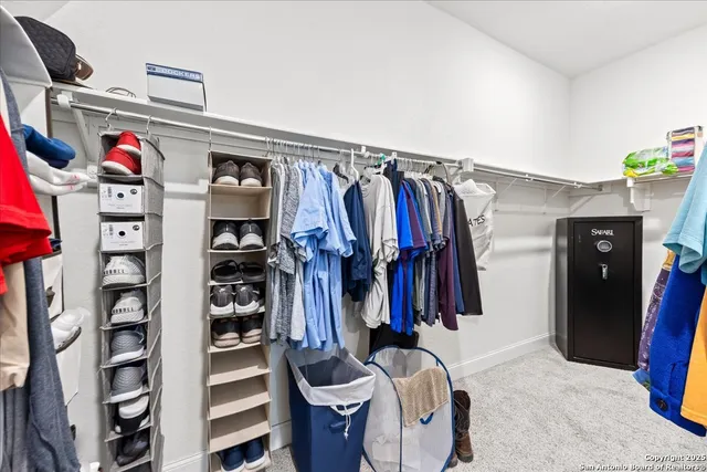 a view of walk in closet with clothes and shoes