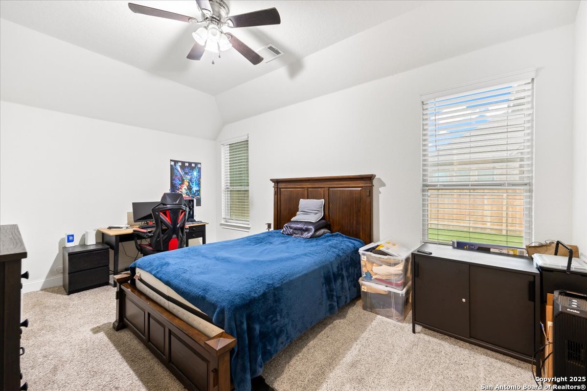 6957 Hallie Loop Schertz, TX 78154 - Photo 32 of 51 a bedroom with a bed and a chandelier