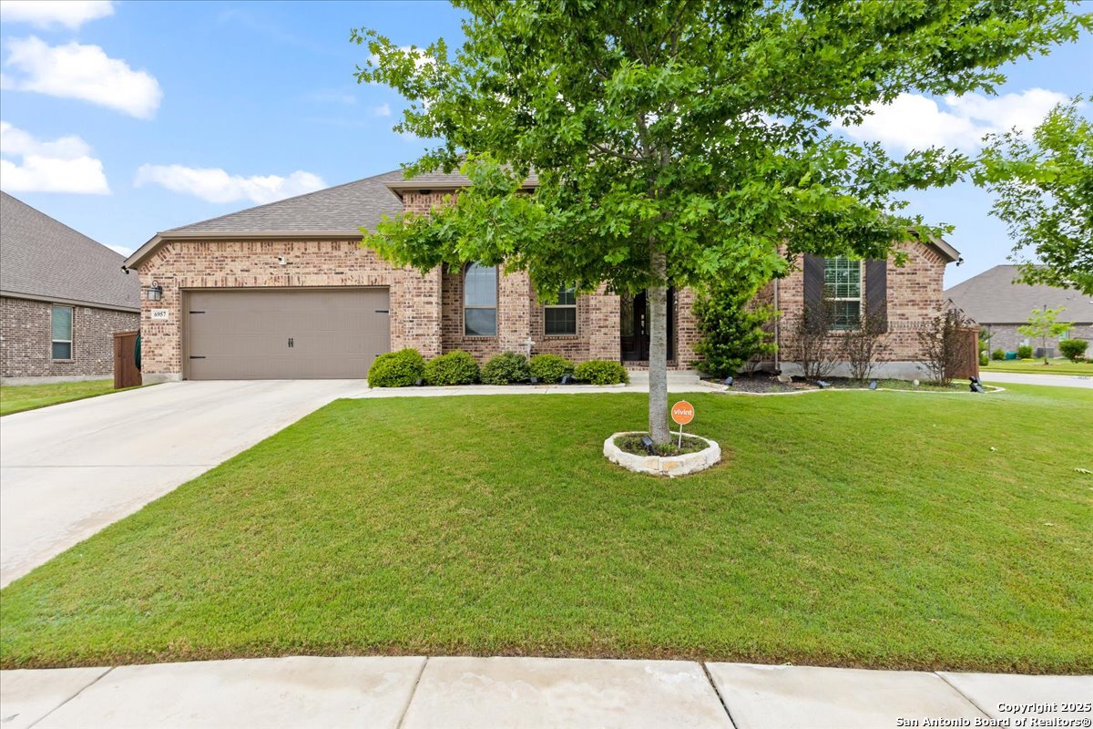 6957 Hallie Loop Schertz, TX 78154 - Photo 4 of 51 a front view of a house with garden and trees