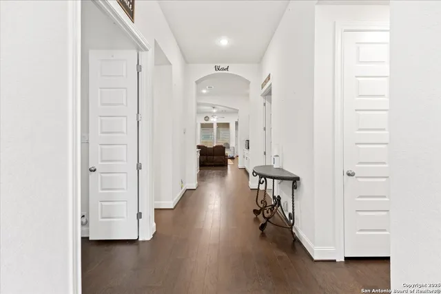 a view of a hallway with wooden floor and closet